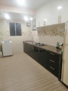 a kitchen with a counter top and a refrigerator at Zulcity Homestay in Gelugor