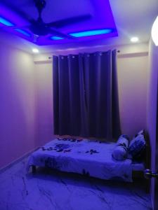 a room with a bed with a purple light at Zulcity Homestay in Gelugor