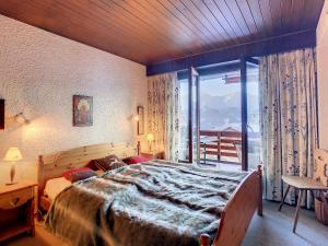 a bedroom with a large bed and a large window at Porthos 29-30 in Verbier