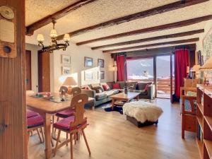 een woonkamer met een tafel en stoelen en een bank bij Porthos 29-30 in Verbier
