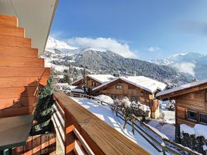 a view of a snowy mountain from the balcony of a house at Porthos 29-30 in Verbier