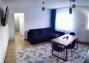 a living room with a table and a blue couch at Cavnic Hills Apartments in Cavnic