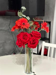 un vase rempli de fleurs rouges sur une table dans l'établissement LA LOGGIA, à Rome