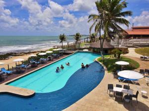 uma vista superior de uma piscina ao lado da praia em Aram Imirá Beach Resort em Natal