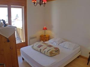 a bedroom with a bed and a window and a lamp at Appartement Samoëns, 3 pièces, 6 personnes - FR-1-629-17 in Samoëns