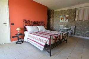 um quarto com uma cama com uma parede laranja em La Rola em Albaretto Della Torre 