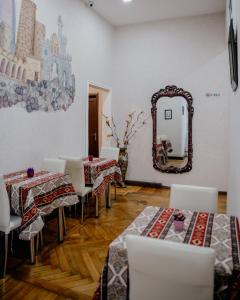 City Inn Nizami Boutique Hotel في باكو: غرفة طعام مع طاولات ومرآة على الحائط