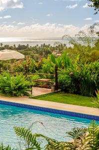 a swimming pool with a view of the ocean at Pousada Mar à Vista in Trancoso