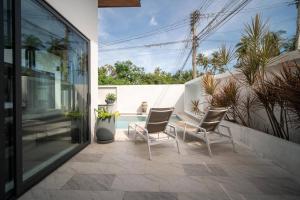 eine Terrasse mit 2 Stühlen und einem Pool in der Unterkunft KOTE Private Pool Villa in Nathon Bay