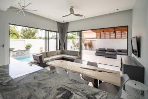 een woonkamer met een tafel en een bank bij KOTE Private Pool Villa in Nathon Bay