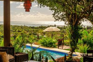 a resort with a pool and a view of the ocean at Pousada Mar à Vista in Trancoso