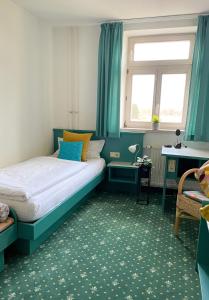 a small bedroom with a bed and a window at Hotel am Friedberger See in Friedberg