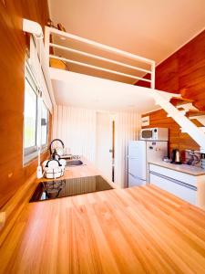 a kitchen with wooden floors and a staircase in a room at Tiny House Aire en La Juanita in José Ignacio