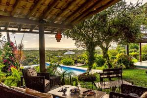 un patio con mesa, sillas y piscina en Pousada Mar à Vista, en Trancoso