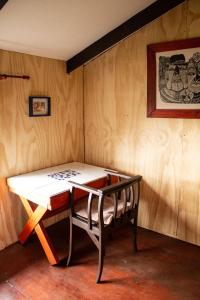 a table and a chair in a room with wooden walls at Azurita in Futaleufú