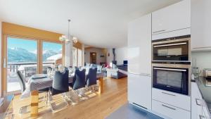 eine Küche und ein Esszimmer mit einem Tisch und Stühlen in der Unterkunft Ski Heaven LUXE & CENTER apartments in Veysonnaz