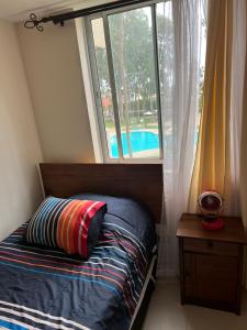 YecoAcogedor Dpto Algarrobo Norte Home Office Wifi Piscinas Hidromasaje的一间卧室设有床、窗户和游泳池 更多16张照片