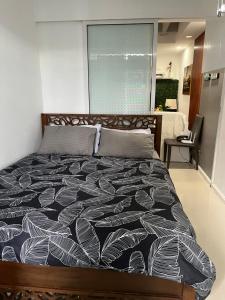 een slaapkamer met een bed met een zwart-wit dekbed bij 2br condo unit Azure Residences by Ms. M in Manilla