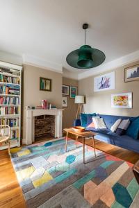 a living room with a blue couch and a table at Lindley Terrace - Norfolk Holiday Properties in Norwich