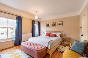 a bedroom with a bed and a couch at Lindley Terrace - Norfolk Holiday Properties in Norwich