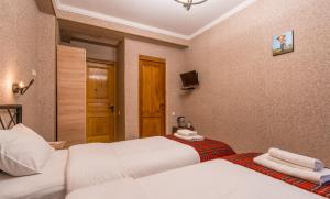 a hotel room with two beds and a television at Hotel at Gomi 19 in Tbilisi City