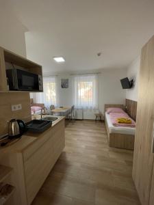 Habitación con cocina y dormitorio con cama. en Dóra Vendégház, en Csongrád