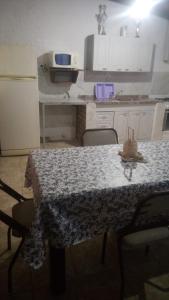 cocina con mesa y cocina con nevera en Alojamiento La Georgi 1 en Luján de Cuyo