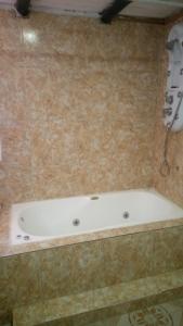 y baño con bañera y pared de azulejos. en Alojamiento La Georgi 1 en Luján de Cuyo