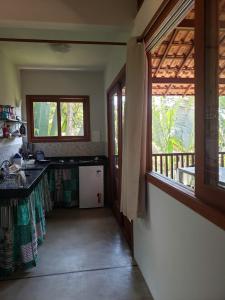 a kitchen with a counter and a window at Chalés Cumuruxatiba in Cumuruxatiba +67 photos