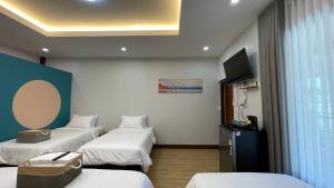 pokój hotelowy z 3 łóżkami i telewizorem w obiekcie THA PAE SUNG - ท่าแพซุง w mieście Uthai Thani