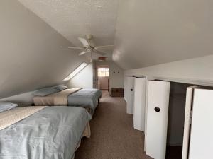 a bedroom with two beds and a ceiling fan at Casa Madre Chic Lakefront Cottage near Ann Arbor in Whitmore Lake