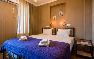 a bedroom with a bed with two towels on it at Hotel at Gomi 19 in Tbilisi City