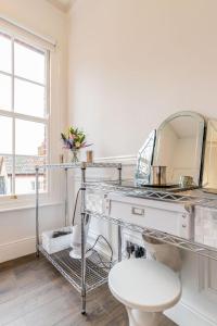 a bathroom with a sink and a mirror at All Saints Green Cottage - Norfolk Holiday Properties in Norwich