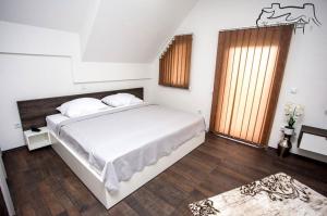 a bedroom with a large white bed and a window at Villa Ostrovica in Bihać
