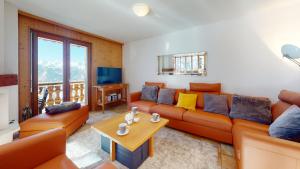 ein Wohnzimmer mit einem Sofa und einem Tisch in der Unterkunft Balcons du Soleil QUIET & SUNNY apartments by Alpvision Résidences in Veysonnaz