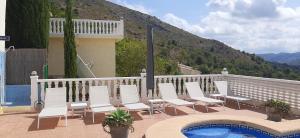 een groep stoelen en een zwembad op een balkon bij Casa Gran Vista, appartement, adults only in Jalón