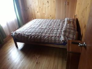a bed in a room with a wooden floor at Hostal Rayen in Villarrica