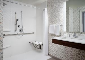 a white bathroom with a sink and a shower at Holiday Inn Boston - Dedham Hotel & Conference Center, an IHG Hotel in Dedham