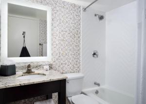 a bathroom with a sink and a toilet and a mirror at Holiday Inn Boston - Dedham Hotel & Conference Center, an IHG Hotel in Dedham