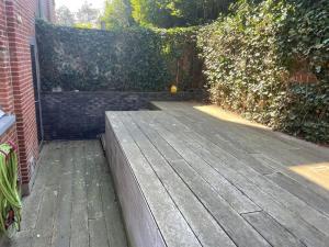 a wooden deck in front of a brick wall at Cozy 3BD House with private terrace and parking in Knokke-Heist