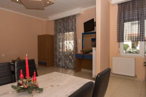 a dining room with a table with red candles at Tzamtzis Apartments in Keramoti