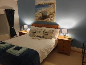um quarto com uma cama com dois candeeiros e uma pintura na parede em Sheviock Barton Bed & Breakfast em Sheviock