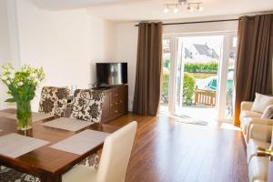 a dining room with a table and chairs and a television at Quayside Cottage - Norfolk Holiday Properties in Wroxham