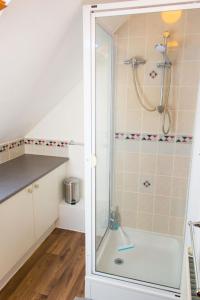 Quayside Cottage - Norfolk Holiday Properties في روكسهام: دش مع باب زجاجي في الحمام