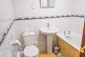 a bathroom with a toilet and a sink at Quayside Cottage - Norfolk Holiday Properties in Wroxham