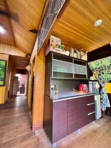 Il comprend une cuisine avec des murs en bois et du parquet. dans l'établissement Villa Mak Intan, Che'Pa Village Langkawi, à Kuah