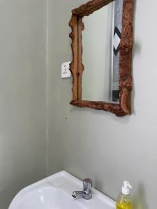 a bathroom with a sink and a mirror on the wall at Mtei Safaris Hostel in Arusha