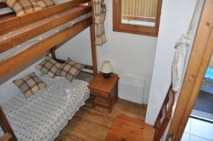 a small bedroom with a bunk bed and a table at Appartement cosy Peisey Les Arcs 6-8 pers - piscine sauna - en face des pistes in Peisey-Nancroix +16 photos