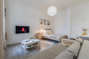 a living room with a couch and a tv on a wall at BOHO RÁJ v centru / /gril/ /balkón in Olomouc