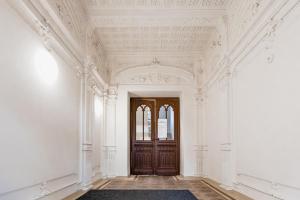 an empty hallway with a wooden door and ceilings at BOHO RÁJ v centru / /gril/ /balkón in Olomouc